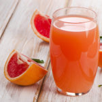 Fresh grapefruit juice  on a wooden table. Selective focus